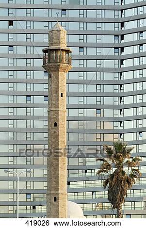 Minaret of a mosque in front of modern office block View Large Photo Image Stock Photograph - Minaret of a mosque in front of modern office block. Fotosearch