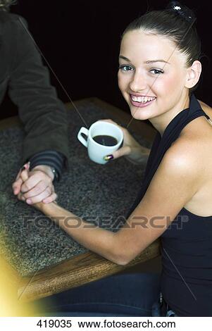 Woman drinking coffee in a cafe with boyfriend View Large Photo Image Stock Photography - Woman drinking coffee in a cafe with boyfriend. Fotosearch