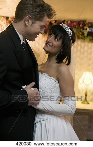 Bride and groom holding hands and staring into each others eyes View Large Photo Image Stock Image - Bride and groom holding hands and staring into each others eyes. Fotosearch