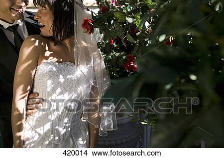 Bride and groom standing together in a garden View Large Photo Image Picture - Bride and groom standing together in a garden. Fotosearch