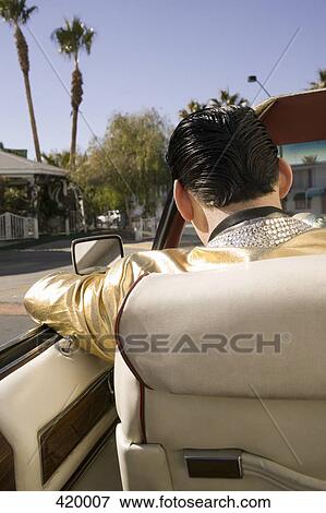 Elvis impersonator driving a vintage convertible car View Large Photo Image Stock Photo - Elvis impersonator driving a vintage convertible car. Fotosearch