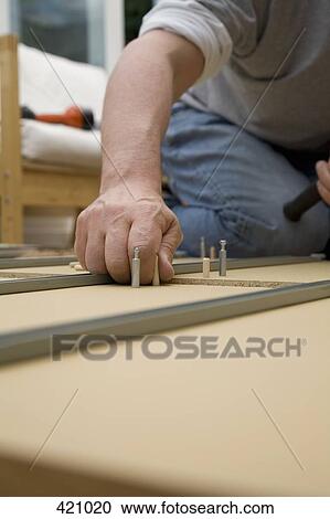 A man assembling furniture View Large Photo Image Stock Image - A man assembling furniture. Fotosearch