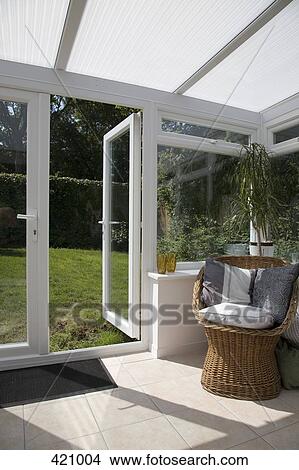 Conservatory with an open door leading to the backyard View Large Photo Image Picture - Conservatory with an open door leading to the backyard. Fotosearch