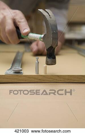 Man using a hammer to assemble furniture View Large Photo Image Stock Image - Man using a hammer to assemble furniture. Fotosearch