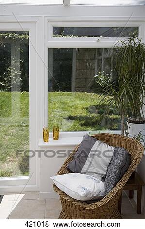 Stock Photo - Wicker chair in a conservatory. Fotosearch
