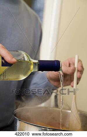 A man adding white wine to a saucepan View Large Photo Image Stock Image - A man adding white wine to a saucepan. Fotosearch