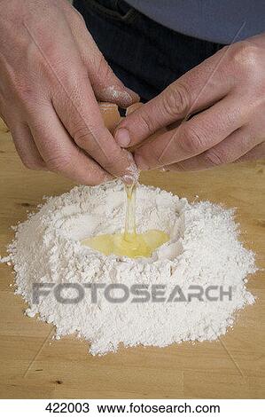 A man cracking an egg into a pile of flour View Large Photo Image Stock Image - A man cracking an egg into a pile of flour. Fotosearch
