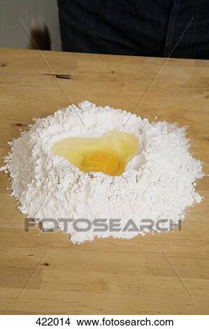 Picture - Flour and egg on a kitchen counter. Fotosearch