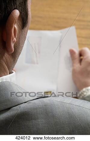 Stock Image - Businessman opening an envelope. Fotosearch