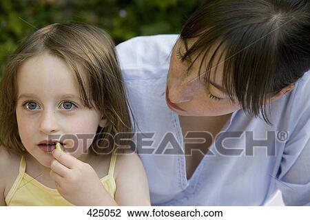 A mother looking at her daughter eating View Large Photo Image Stock Image - A mother looking at her daughter eating. Fotosearch