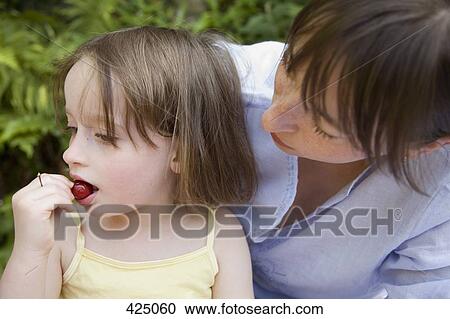 A mother looking at her daughter eating View Large Photo Image Stock Image - A mother looking at her daughter eating. Fotosearch