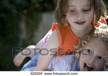 Girls playing in a backyard View Large Photo Image Stock Photo - Girls playing in a backyard. Fotosearch