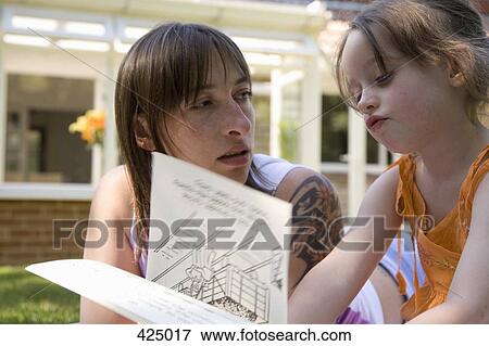 Mother and daughter reading a book together in a backyard View Large Photo Image Stock Photo - Mother and daughter reading a book together in a backyard. Fotosearch