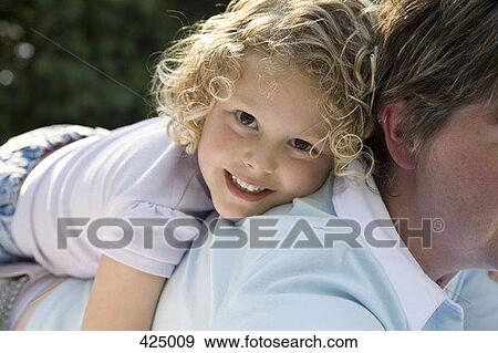 Young girl riding on her mother's back View Large Photo Image Stock Photo - Young girl riding on her mother's back. Fotosearch