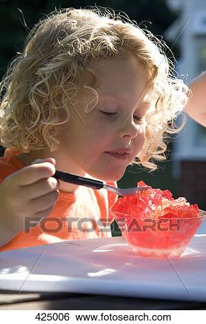 Young girl sitting in a backyard eating jello View Large Photo Image Stock Photograph - Young girl sitting in a backyard eating jello. Fotosearch