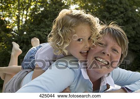 Young girl with her arms around her mother View Large Photo Image Picture - Young girl with her arms around her mother. Fotosearch