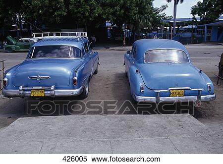 Stock Photography - Two vintage cars parked side by side, Cuba. Fotosearch