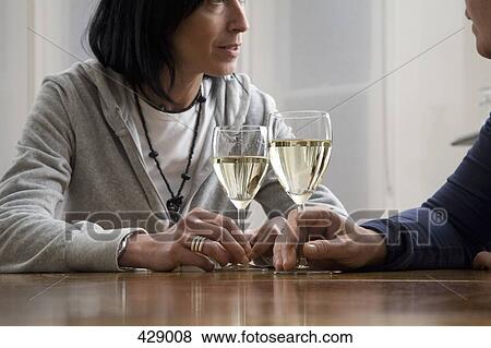 Stock Photo - A couple drinking wine at a dining table. Fotosearch