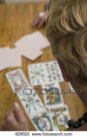 A woman reading tarot cards at a table View Large Photo Image Stock Image - A woman reading tarot cards at a table. Fotosearch