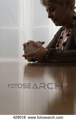 Stock Photo - A woman shuffling tarot cards. Fotosearch