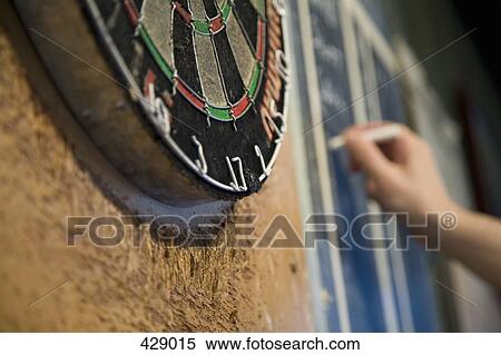 Stock Photography - Person keeping score on a blackboard during a game of darts. Fotosearch