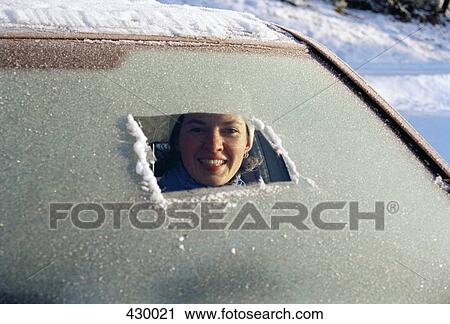 Woman sitting in car a and peeking through a frost covered windshield View Large Photo Image Stock Image - Woman sitting in car a and peeking through a frost covered windshield. Fotosearch
