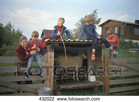 Stock Image - Children sitting on fence. Fotosearch