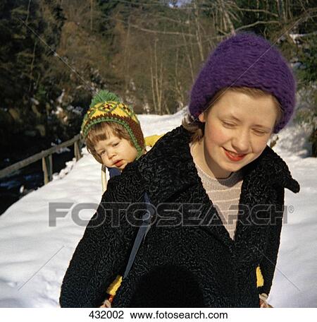 Mother carrying child on her back View Large Photo Image Stock Image - Mother carrying child on her back. Fotosearch