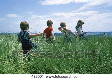 Rear view of four children walking through a field View Large Photo Image Stock Image - Rear view of four children walking through a field. Fotosearch