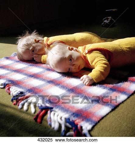 Two babies lying on rug View Large Photo Image Stock Photography - Two babies lying on rug. Fotosearch