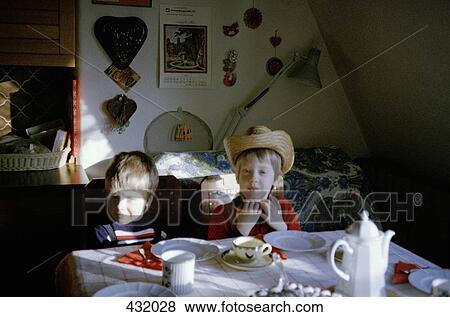 Two boys sitting at the dining table View Large Photo Image Stock Photo - Two boys sitting at the dining table. Fotosearch