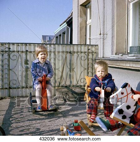 Two toddlers playing on rocking horses on balcony View Large Photo Image Stock Photograph - Two toddlers playing on rocking horses on balcony. Fotosearch