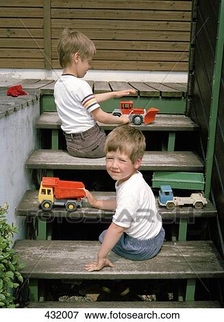 Two young boys playing with toys on steps View Large Photo Image Stock Photo - Two young boys playing with toys on steps. Fotosearch