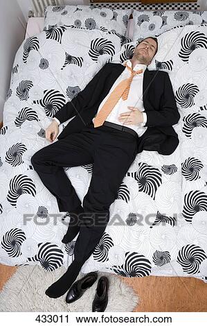 Businessman sleeping on a bed View Large Photo Image Stock Image - Businessman sleeping on a bed. Fotosearch