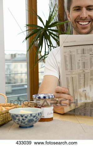 Man reading a newspaper over breakfast View Large Photo Image Stock Photo - Man reading a newspaper over breakfast. Fotosearch