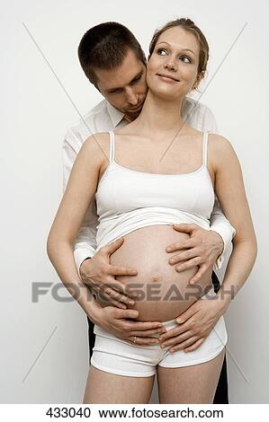 Pregnant couple embracing View Large Photo Image Stock Image - Pregnant couple embracing. Fotosearch