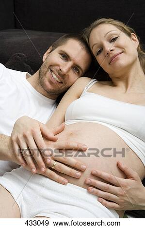 Pregnant couple lying down together View Large Photo Image Stock Photo - Pregnant couple lying down together. Fotosearch