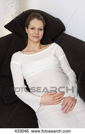 Pregnant woman relaxing on a sofa View Large Photo Image Stock Photograph - Pregnant woman relaxing on a sofa. Fotosearch