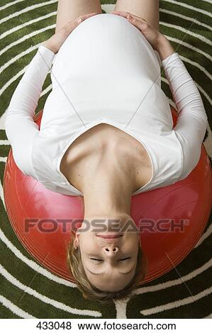 Pregnant woman stretching on a fitness ball View Large Photo Image Stock Photo - Pregnant woman stretching on a fitness ball. Fotosearch