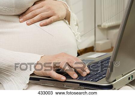 Pregnant woman using a laptop computer View Large Photo Image Stock Image - Pregnant woman using a laptop computer. Fotosearch