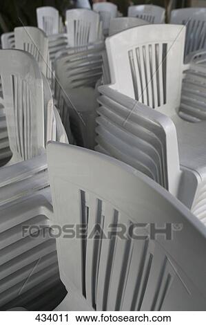 Stacked white plastic chairs View Large Photo Image Stock Image - Stacked white plastic chairs. Fotosearch