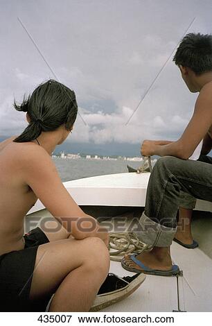Two men sitting in a boat View Large Photo Image Stock Photo - Two men sitting in a boat. Fotosearch