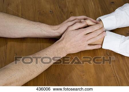 A couple holding hands across a table View Large Photo Image Stock Photograph - A couple holding hands across a table. Fotosearch