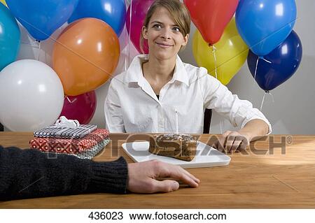 Couple sitting at table with birthday cake and balloons View Large Photo Image Stock Image - Couple sitting at table with birthday cake and balloons. Fotosearch