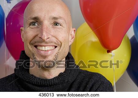 Man sitting in front of balloons View Large Photo Image Stock Image - Man sitting in front of balloons. Fotosearch