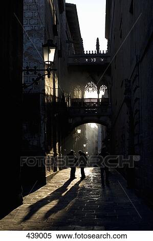 Stock Photography - Two people standing in a laneway at sunset. Fotosearch