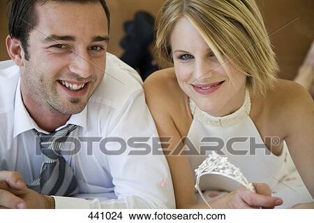 Picture - A bride and a groom lying down on a bed together. Fotosearch