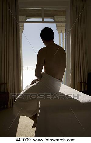 A man wrapped in a towel and sitting at the edge of a massage table View Large Photo Image Stock Photo - A man wrapped in a towel and sitting at the edge of a massage table. Fotosearch
