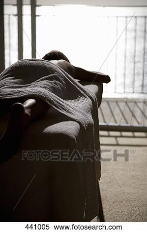 A woman lying down on a massage table View Large Photo Image Stock Photography - A woman lying down on a massage table. Fotosearch