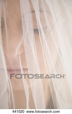 Stock Image - Close-up of a bride under a veil. Fotosearch